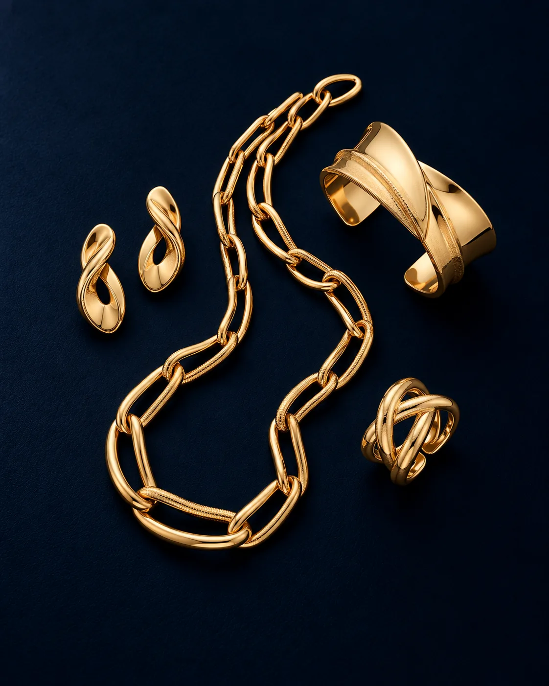 Polished Italian gold link chain with twisted earrings, cuff and ring on navy
