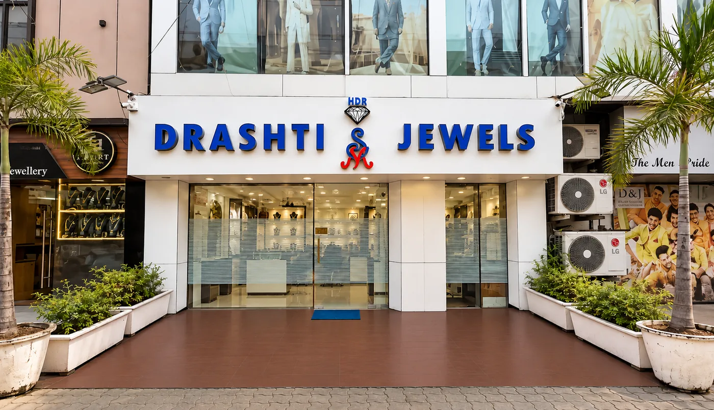 The Drashti Jewels showroom front on Amin Marg in daylight, with the signboard above the glass entrance